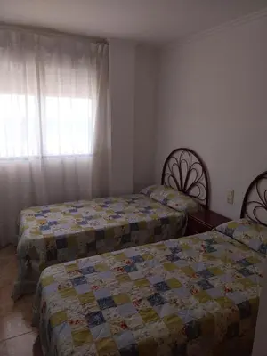 a bedroom with two beds and a window at Parquemar I Solo Familias Serviplaya in Casas Las Basas