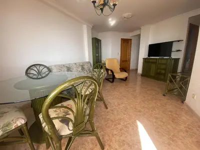 a living room with a table and chairs and a television at Parquemar I Solo Familias Serviplaya in Casas Las Basas