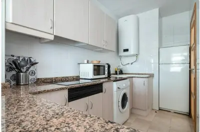 a kitchen with a washer and a white refrigerator at Bet Apartments - Sunrise Beach Apartments in Valencia