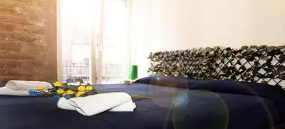 a blue bed with towels and flowers on it at Loft independiente con Piscina compartida en Centro de Valencia in Valencia