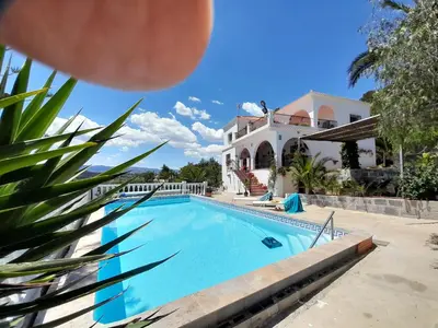 a villa with a swimming pool in front of a house at Casa Loro Loco B&B in Pedralba