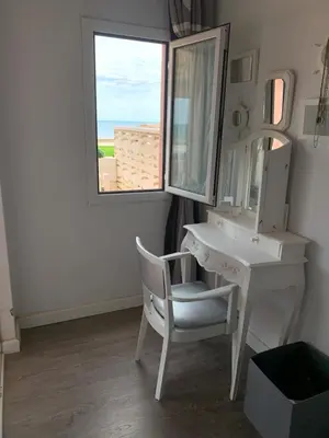 a bathroom with a white vanity and a mirror and a chair at Apartamento primera línea de playa in Port Saplaya