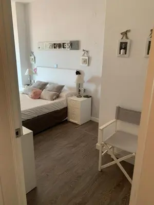 a small bedroom with a bed and a chair at Apartamento primera línea de playa in Port Saplaya