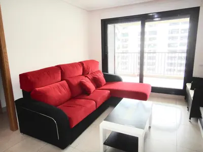 a red couch in a living room with a window at Patacona Beach Power!! in Valencia