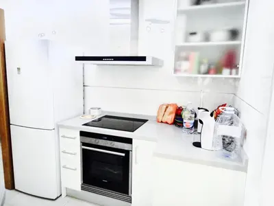 a white kitchen with a stove and a refrigerator at Patacona Beach Power!! in Valencia