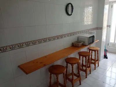 a patio with columns and a chair on a building at Mar Azul Solo Familias Serviplaya in Casas Las Basas