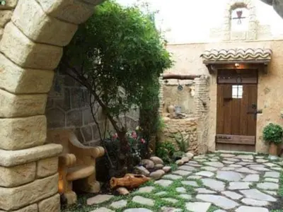 a stone building with a door and a stone walkway at A la Sombra de la Torre in Serra