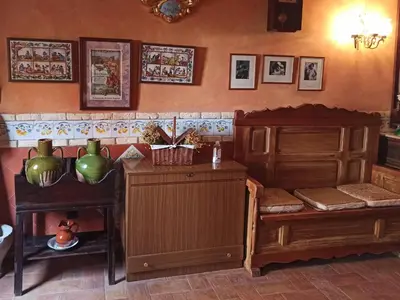 a kitchen with wooden furniture and pictures on the wall at A la Sombra de la Torre in Serra