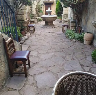 a stone patio with chairs and a fountain at A la Sombra de la Torre in Serra