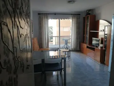 a living room with a table and chairs and a dining room at Apartamento estudio en playa Puig in Valencia