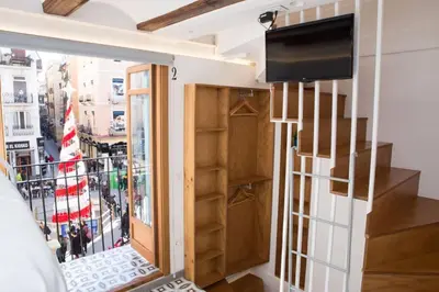 a room with a balcony with a tv and a window at Finca Reloj in Valencia