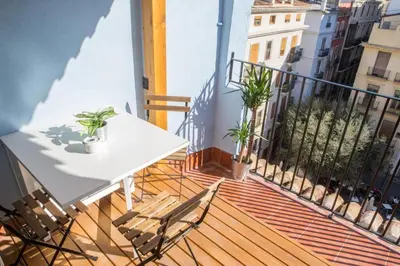 a balcony with a white table and chairs at Finca Reloj in Valencia