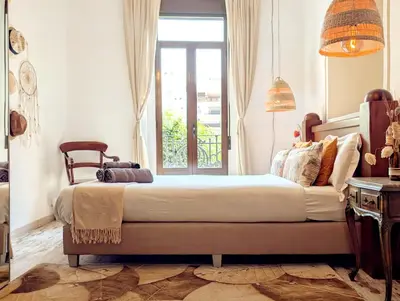 two beds in a room with a window at Portrait Boutique Guesthouse in Valencia