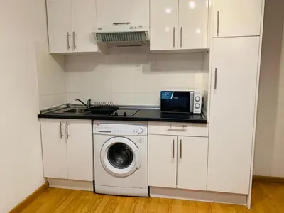 a kitchen with a washing machine and a microwave at Ayuntamiento Silence in Valencia