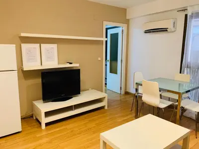 a living room with a tv and a table with chairs at Ayuntamiento Silence in Valencia