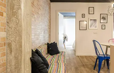 a living room with a couch and a brick wall at New Room in the beach in Valencia