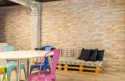 a table and chairs with a couch against a brick wall at New Room in the beach in Valencia