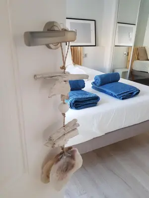 a bedroom with a bed with towels and a mirror at Increible ático con vistas al Mediterraneo by Hometels in Puerto de Sagunto