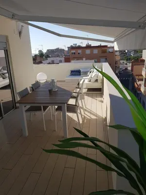 a balcony with a table and chairs on a roof at Increible ático con vistas al Mediterraneo by Hometels in Puerto de Sagunto