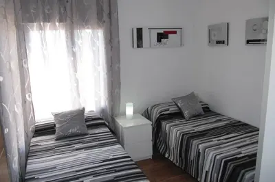 two beds in a small room with a window at piso con estilo cerca de la playa in Cullera