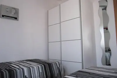 a bedroom with a bed and a white cabinet at piso con estilo cerca de la playa in Cullera