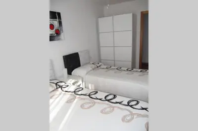 a bedroom with two beds and a mirror at piso con estilo cerca de la playa in Cullera
