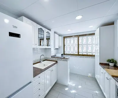 a white kitchen with a sink and a window at NUEVO, a 70 metros de la playa y con vistas al mar in Cullera