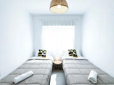 two beds in a room with a window at NUEVO, a 70 metros de la playa y con vistas al mar in Cullera
