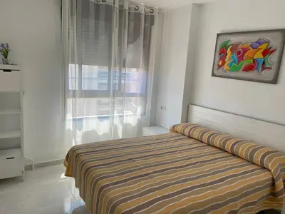 a bedroom with a bed with a painting on the wall at Atico playa Moncofar in Moncófar