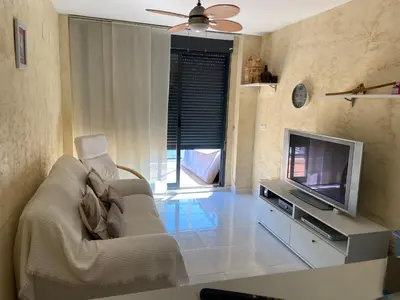 a living room with a couch and a flat screen tv at Atico playa Moncofar in Moncófar