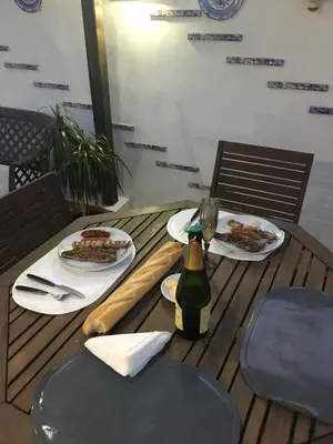 a wooden table with plates of food and a bottle of wine at Atico playa Moncofar in Moncófar