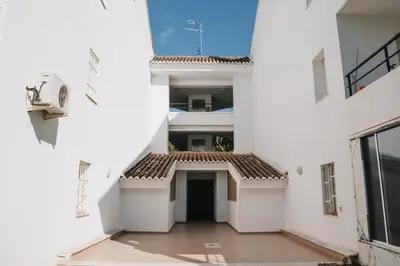 an empty hallway of a white building with a courtyard at Apartamento luminoso cerca del mar y la montaña in Puzol