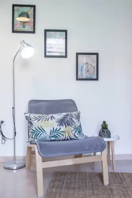 a chair with a pillow and a lamp in a room at Tranquilo y acogedor en el centro de la ciudad in Valencia