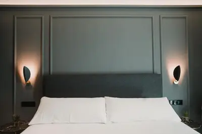 a bedroom with a bed with two lights above it at Reina 107 Beach Boutique in Valencia