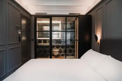 a bedroom with a bed and a glass door at Reina 107 Beach Boutique in Valencia