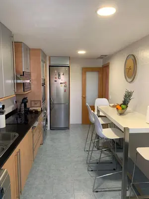 a kitchen with a refrigerator and a table with chairs at Art and Sciences view luxury apartment in Valencia