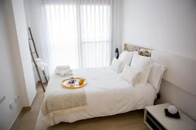 a bedroom with a white bed with a tray of fruit on it at Art and Sciences view luxury apartment in Valencia