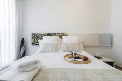 a white bed with a tray of food on it at Art and Sciences view luxury apartment in Valencia