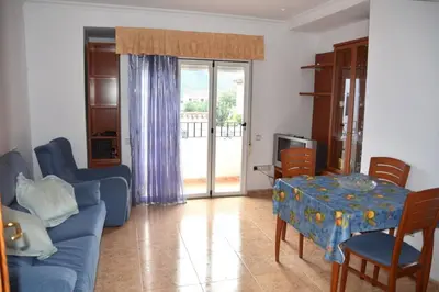 a living room with a blue couch and a table at APARTAMENTOS GALLACH (LA ERMITA) in Chulilla