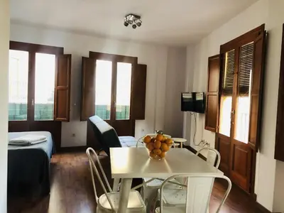 a living room with a table and chairs in a room at 123rooms in Valencia