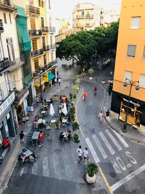 a group of people sitting at tables on a city street at 123rooms in Valencia