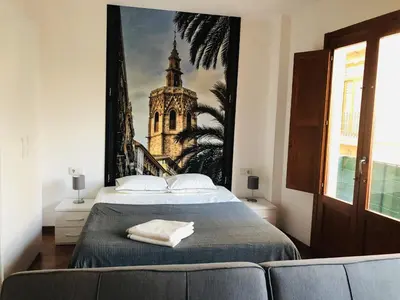 a bedroom with a bed and a painting of a church at 123rooms in Valencia