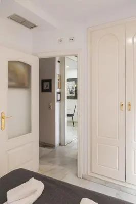 a bedroom with a door leading into a room with a chair at Serrano Park in Valencia