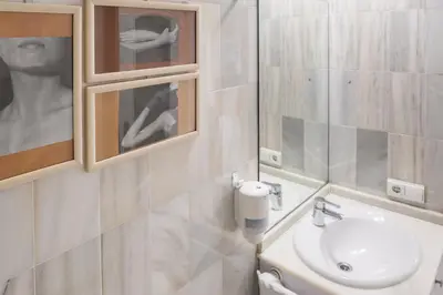 a white bathroom with a sink and a mirror at Serrano Park in Valencia