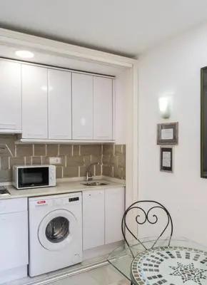 a kitchen with a washing machine and a microwave at Serrano Park in Valencia