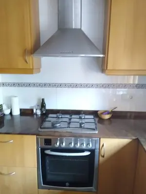 a stove top oven in a kitchen with a hood at Casa de Amparo y José Manuel en Pavias in Pavías