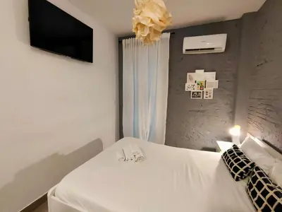 a bedroom with two white beds and a television at Pequeño Alojamiento con Mini Piscina - NO climatizada in Valencia