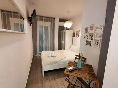 a small bedroom with a bed and a table at Pequeño Alojamiento con Mini Piscina - NO climatizada in Valencia