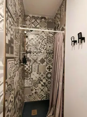 a bathroom with a shower with black and white tiles at Pequeño Alojamiento con Mini Piscina - NO climatizada in Valencia