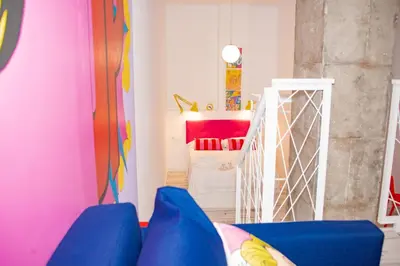 a living room with a blue couch and a pink room at Soraya's Place - Chopín 3 in Valencia